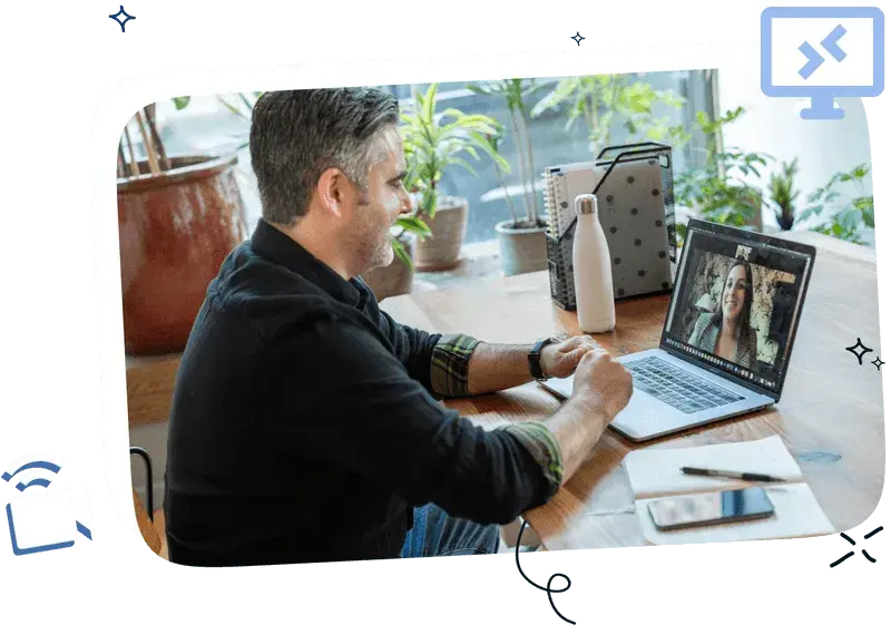 A man sitting in front of a laptop talking to a colleague from abroad